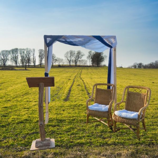 pack-ceremonie-champetre-bleu-roi Arche et pupitre en bois marron avec deux fauteuils en osier et voilage bleu roi