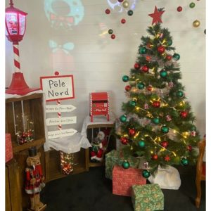 salon du père Noel avec fauteuil sapin et déco festives rouge et blanches