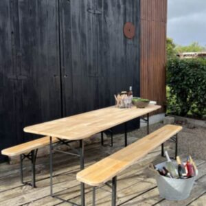 Tablée de fête en bois avec bancs et bouteilles de Champagne